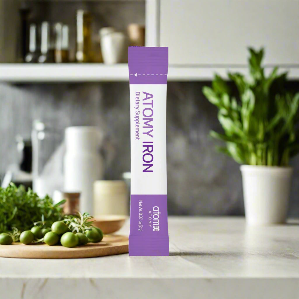 Purple and white supplement stick pack with 'ATOMY' branding on a white background